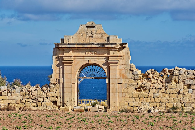 La vue de l'ancienne porte en ruine de la villa date du bleu de la mer et du ciel