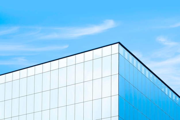 Vue à angle bas du gratte-ciel en verre avec réflexion de la lumière du soleil sur la surface sur fond de ciel bleu