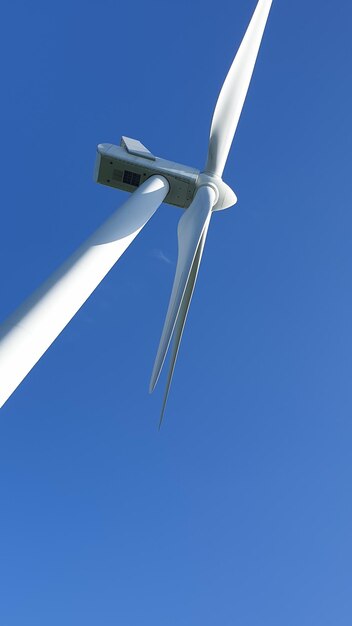 Photo vue d'angle bas de l'éolienne contre un ciel bleu clair