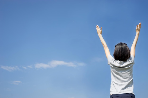 Vue à angle bas d'une femme debout contre le ciel bleu