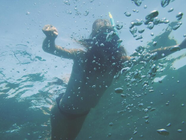 Photo vue d'angle bas d'une femme nageant dans la mer