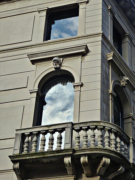 Vue d'angle bas de la fenêtre du bâtiment avec réflexion des nuages