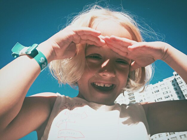 Photo vue à angle bas d'une fille joyeuse contre le ciel