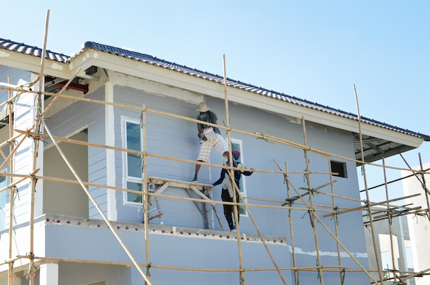 Vue d'angle bas d'un homme travaillant sur un bâtiment contre un ciel dégagé