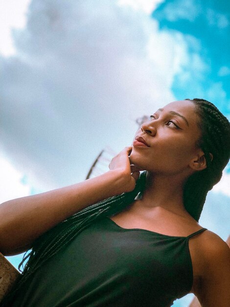 Vue à angle bas d'une jeune femme détournant son regard vers le ciel