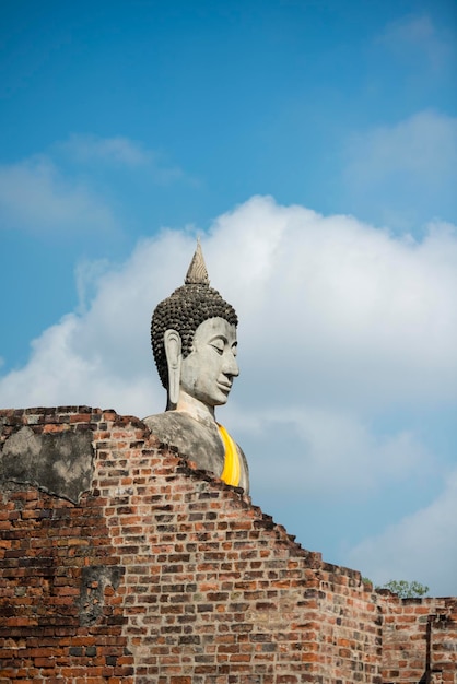 Photo vue à angle bas de la statue de bouddha près du vieux mur de brique à wat yai chai mongkhon