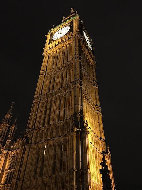 Photo vue d'angle bas de la tour éclairée la nuit.