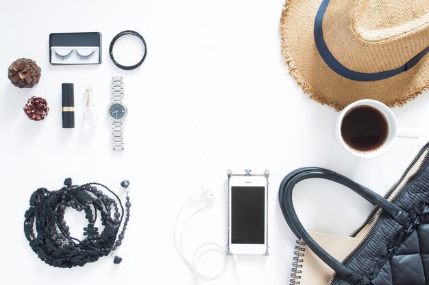 Photo vue d'angle élevé des accessoires personnels avec des cônes de pin sur fond blanc