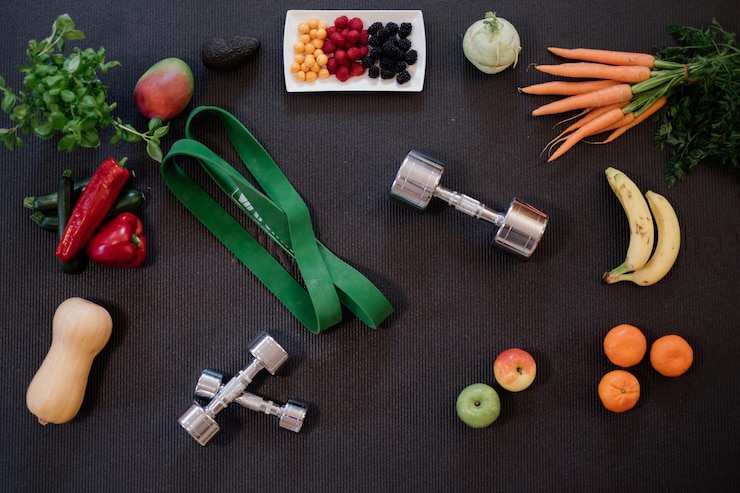 Photo vue d'angle élevé des aliments sains et des haltères d'équipement sportif