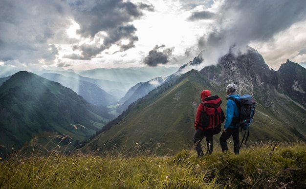 Vue d'angle élevé d'amis debout sur une falaise contre les montagnes