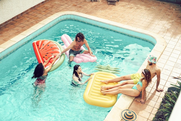 Photo vue d'angle élevé d'amis s'amusant dans la piscine