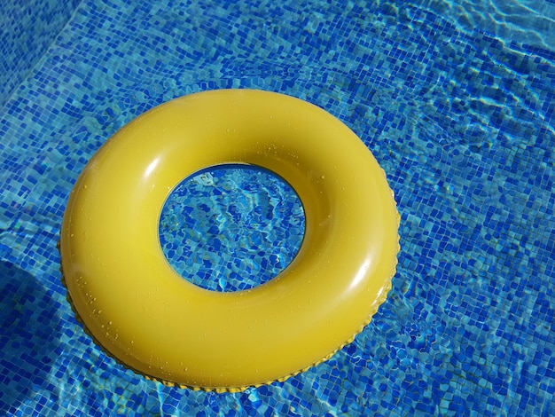 Vue d'angle élevé de l'anneau gonflable jaune dans une piscine