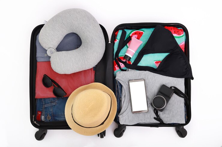 Photo vue d'angle élevé des bagages avec chapeau et vêtements sur fond blanc