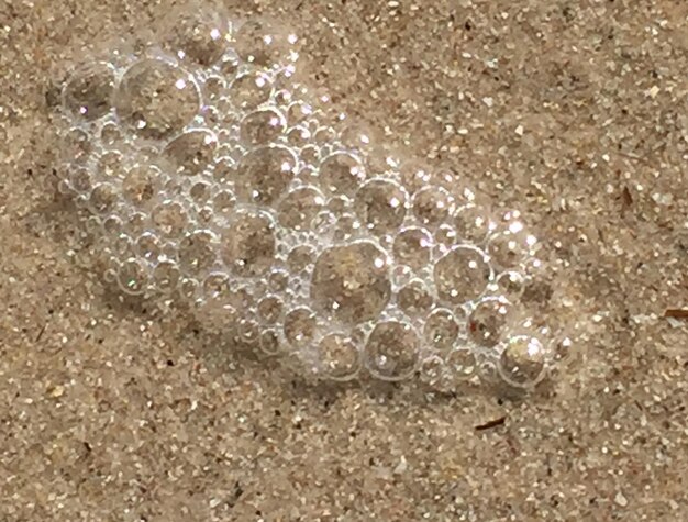 Photo vue d'angle élevé des bulles sur la plage de sable