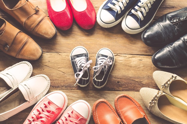 Photo vue d'angle élevé de diverses chaussures sur le sol en bois dur