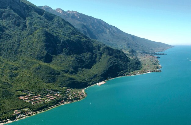 Photo vue d'angle élevé du lac de garde et des montagnes contre le ciel