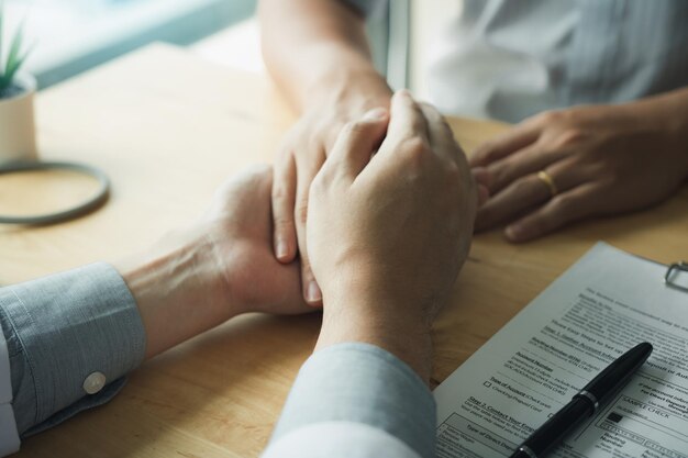 Vue d'angle élevé du médecin réconfortant le patient sur la table