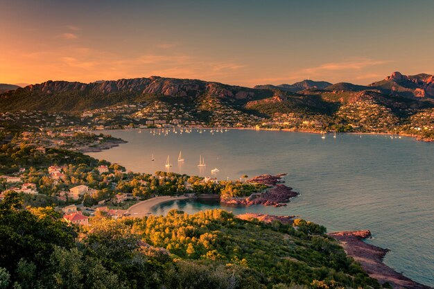 Photo vue d'angle élevé du paysage urbain par la mer contre le ciel au coucher du soleil