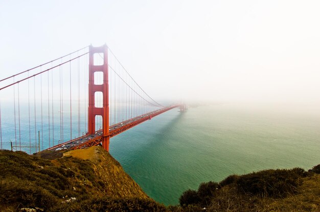 Photo vue d'angle élevé du pont de la porte d'or sur la mer par temps brumeux