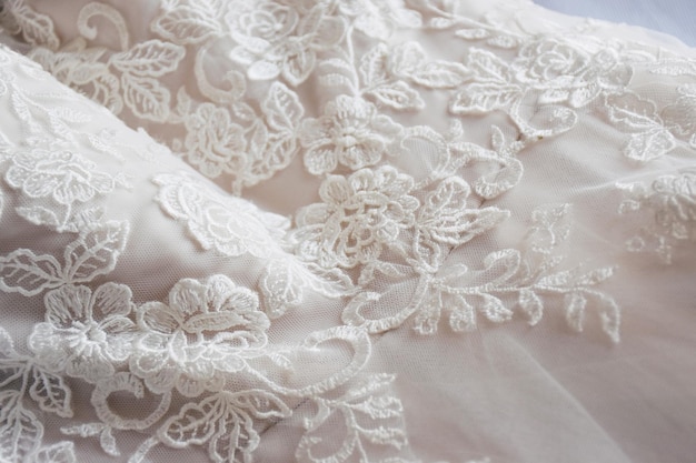 Photo vue d'angle élevé du tissu blanc et des détails de dentelle sur la robe de mariée