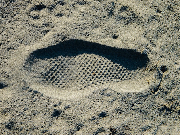 Photo vue d'angle élevé des empreintes de pas sur le sable de la plage