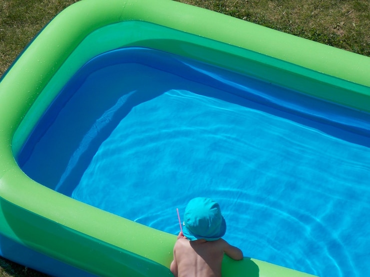Photo vue d'angle élevé d'un enfant appuyé sur une piscine gonflable