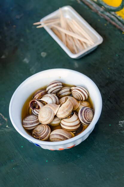 Photo vue d'angle élevé des escargots bouillis dans un bol sur la table