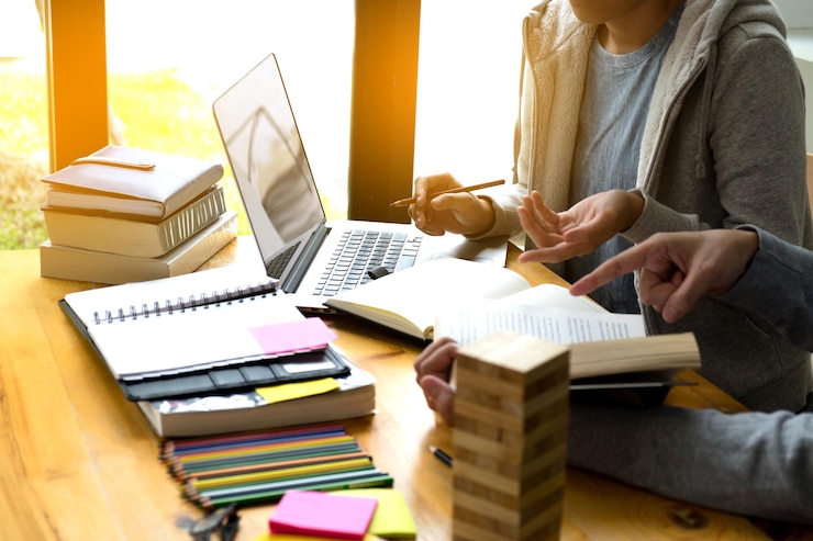 Photo vue d'angle élevé des étudiants discutant sur la table alors qu'ils sont assis dans la bibliothèque