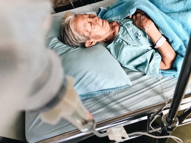 Vue d'angle élevé d'une femme âgée allongée sur un lit à l'hôpital