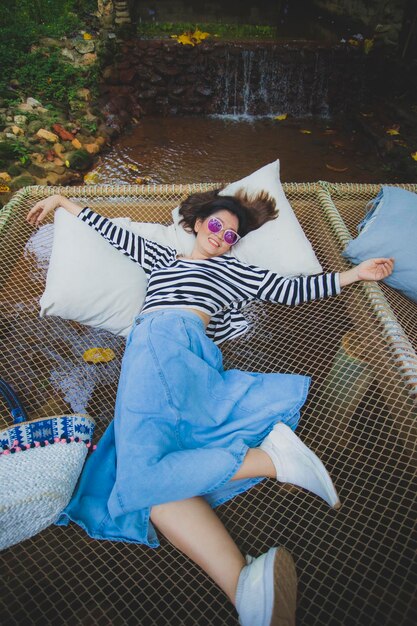 Photo vue d'angle élevé d'une femme se reposant contre une cascade