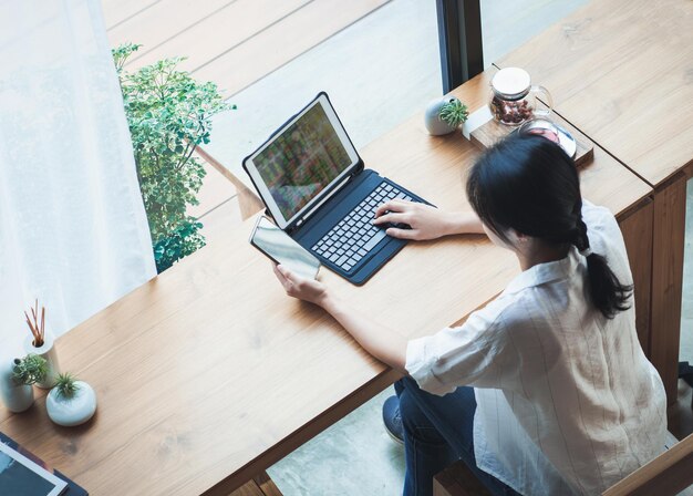 Vue d'angle élevé d'une femme utilisant un ordinateur portable sur la table