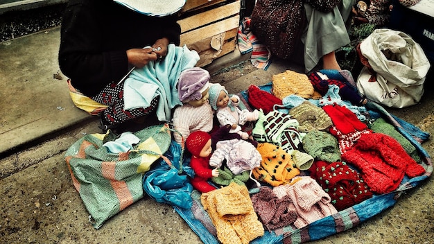 Photo vue d'angle élevé d'une femme vendant des vêtements chauds au marché