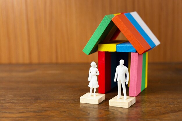 Photo vue d'angle élevé des figurines et de la maison modèle sur table en bois