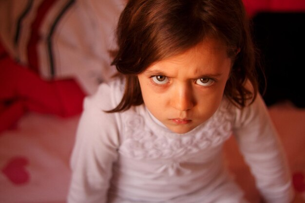 Photo vue d'angle élevé d'une fille assise sur le lit à la maison