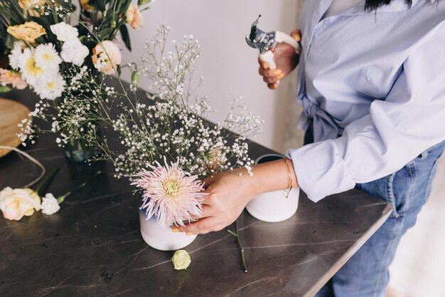 Photo vue d'angle élevé d'un fleuriste faisant un arrangement de fleurs sur un petit vase