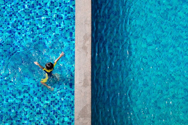 Photo vue d'angle élevé d'un garçon nageant dans la piscine