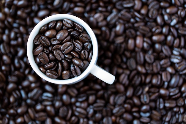 Vue d'angle élevé des grains de café torréfiés dans une tasse