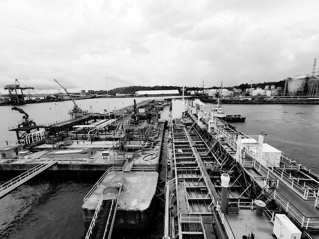 Photo vue d'angle élevé des grues au port contre le ciel