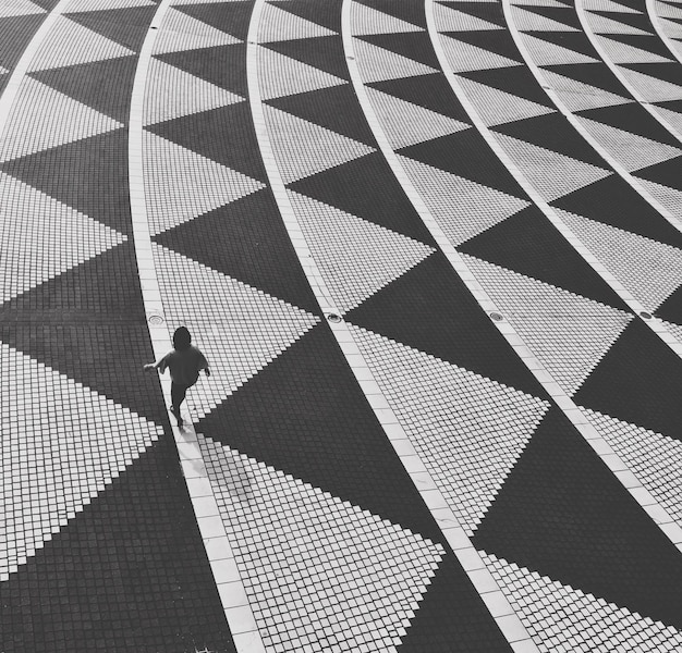 Photo vue d'angle élevé d'un homme marchant sur un sol carrelé