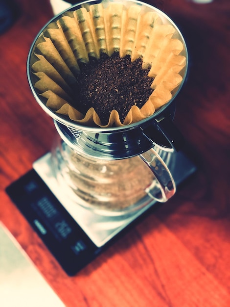 Photo vue à angle élevé de l'infusion de café en v60 sur la table au travail du matin