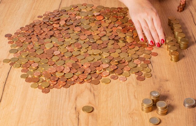 Photo vue d'angle élevé de la main d'une femme comptant des pièces sur la table