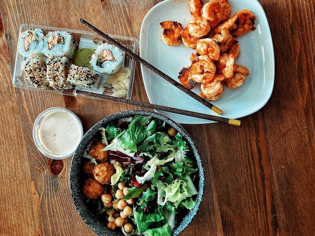 Vue d'angle élevé de la nourriture avec des sushis et des salades sur la table