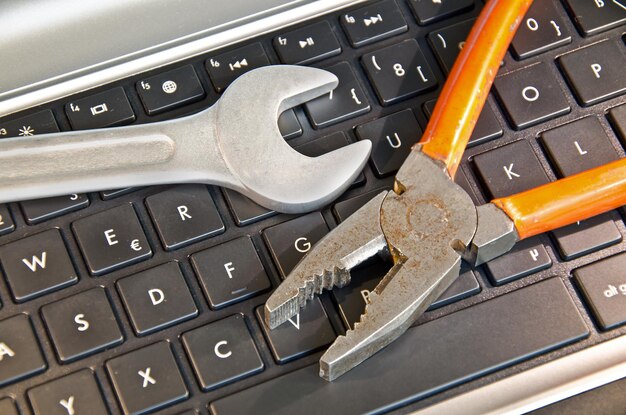 Vue d'angle élevé des outils à main sur le clavier de l'ordinateur
