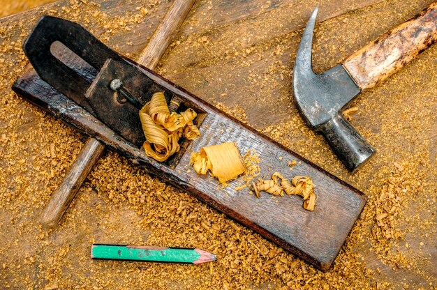 Photo vue d'angle élevé des outils de menuiserie et des copeaux de bois sur la table