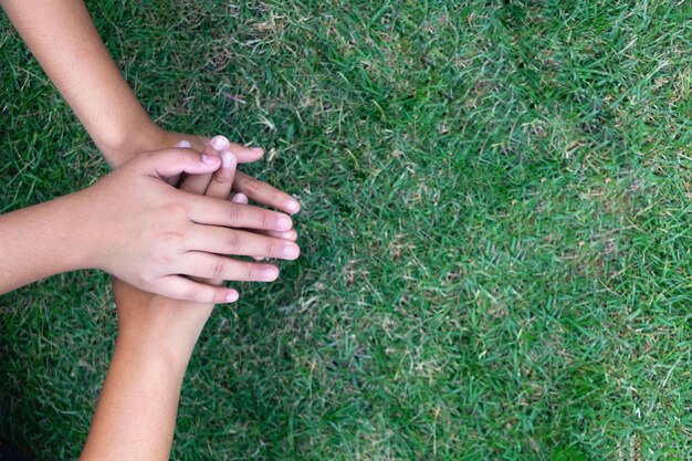 Vue d'angle élevé de personnes empilant les mains sur l'herbe