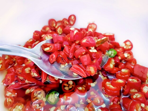 Vue en angle élevé de piments rouges et verts marinés en tranches dans du vinaigre