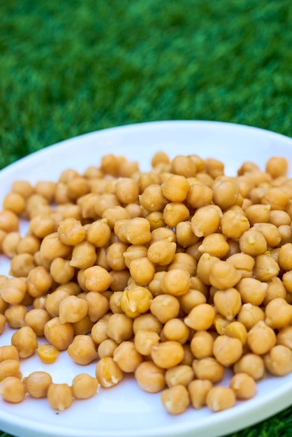 Photo vue d'angle élevé des pois chiches frais dans une assiette sur l'herbe