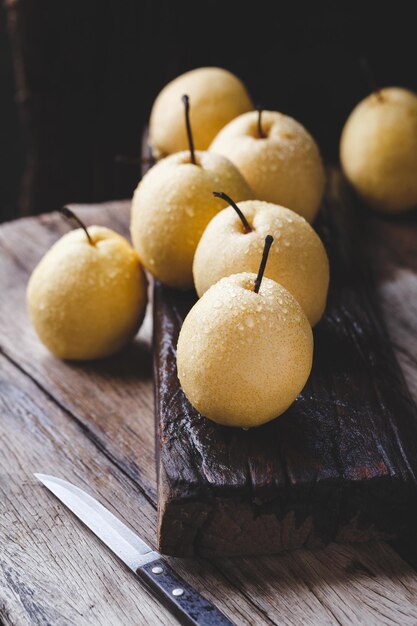 Photo vue d'angle élevé de pommes mouillées dans un plateau sur une table en bois