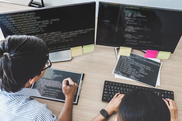 Vue d'angle élevé des programmeurs d'ordinateurs masculins codant au bureau