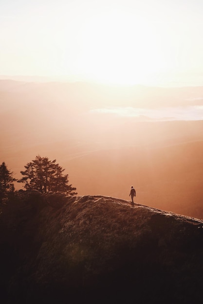 Vue d'angle élevé de la silhouette d'un homme debout sur la montagne contre le ciel